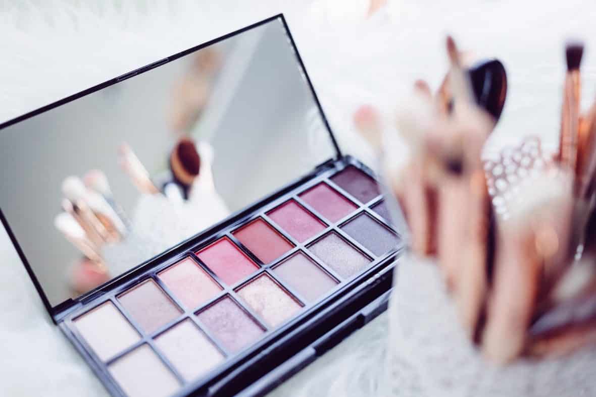 Photo of eyeshadow palette and container of makeup brushes